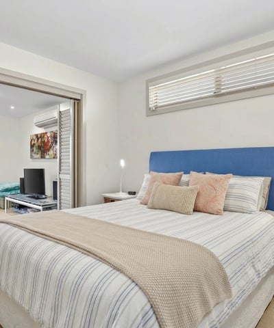 Bright and inviting bedroom with ample natural light, featuring a cozy atmosphere and modern finishes.