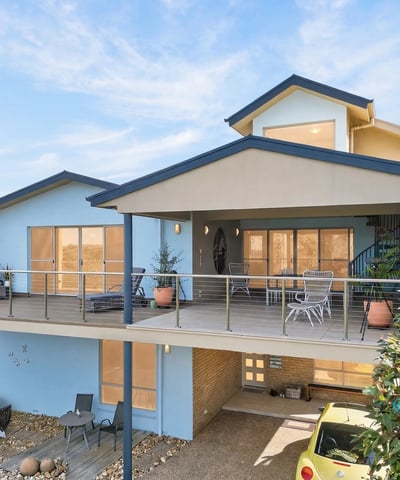 This contemporary home features spacious outdoor living areas and large windows that invite abundant natural light.