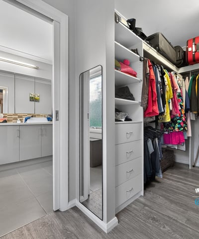 Spacious walk-in closet seamlessly connects to the laundry area, offering practical organization and efficient living.