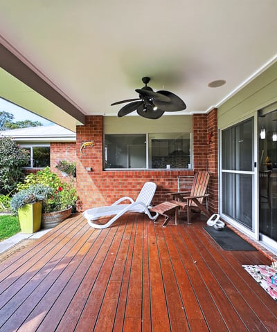 Spacious outdoor deck area perfect for relaxing or entertaining, surrounded by lush greenery and inviting atmosphere.