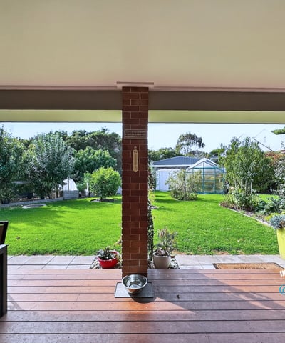 Spacious outdoor patio overlooking a vast, well-maintained garden ideal for entertaining and relaxation.