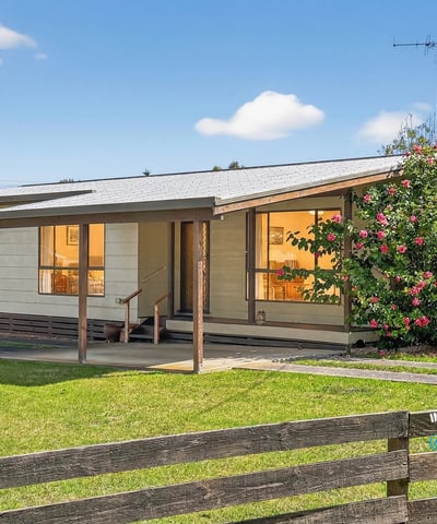 This inviting home features a spacious porch and well-maintained landscaping, perfect for outdoor relaxation.