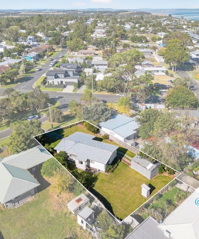 Spacious lot with potential, featuring a cozy home and scenic views near waterfront amenities.