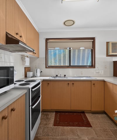 Spacious kitchen featuring ample cabinetry, a modern stove, and natural light throughout. Perfect for cooking enthusiasts.