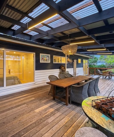 Spacious outdoor deck with ample seating, perfect for relaxed gatherings and enjoying the surrounding greenery.