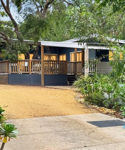 Bright, inviting home set on a spacious lot with a welcoming deck and lush landscaping.