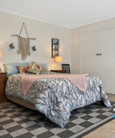 Cozy bedroom featuring botanical decor, abundant natural light, and ample storage for comfortable living.