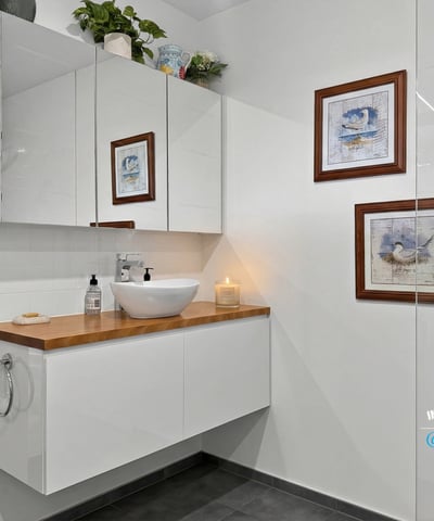 Modern bathroom featuring sleek cabinetry, artistic decor, and contemporary fixtures for a fresh ambiance.