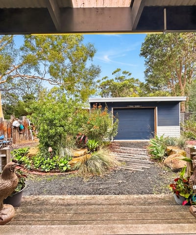 Enjoy a picturesque view of well-maintained gardens and a spacious shed from this outdoor area.
