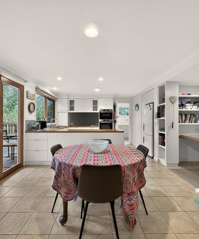 Spacious kitchen with ample natural light, featuring a dining area and convenient workspace for modern living.