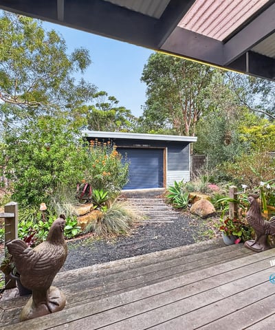 Nestled in lush surroundings, this property features a modern shed and vibrant landscaping perfect for outdoor enthusiasts.