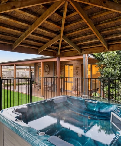Relax in the inviting hot tub surrounded by lush landscaping and a spacious outdoor retreat.