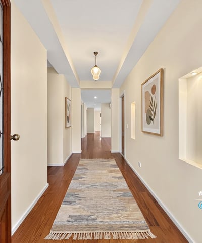 Bright and inviting hallway featuring natural light, modern finishes, and attractive art displays throughout.