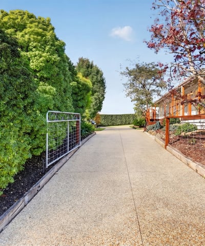 Discover this inviting pathway leading to a beautifully landscaped property, ideal for your future home.
