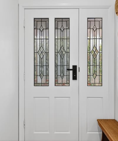 Inviting entryway featuring detailed glass doors and unique wall decor, perfect for welcoming guests.