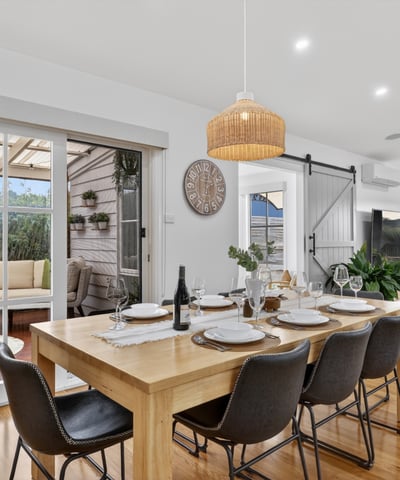 Spacious dining area with natural light, leading to a cozy outdoor retreat for entertaining.