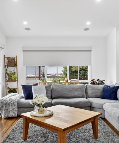 Spacious living area features large windows, offering abundant natural light and a cozy atmosphere.