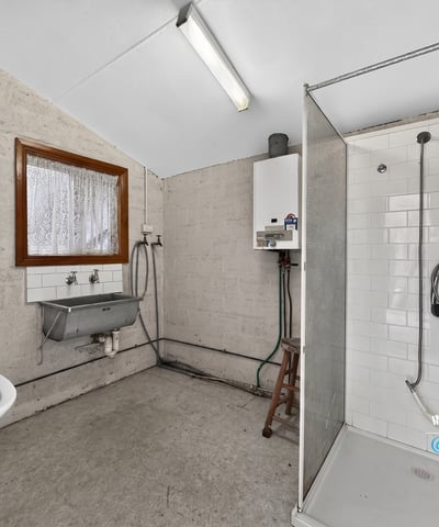 Spacious bathroom featuring a modern shower, practical sink area, and ample natural light.