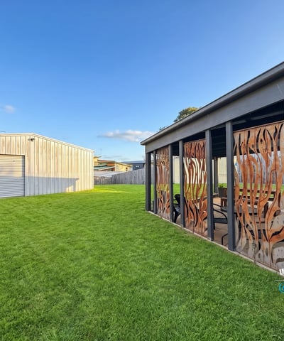 Spacious backyard featuring distinctive decor and a large garage, perfect for outdoor gatherings and hobbies.