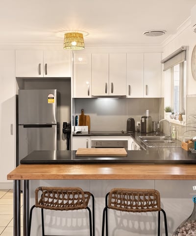 Bright kitchen featuring modern appliances, sleek cabinetry, and a cozy breakfast bar for casual dining.