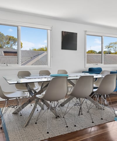 Bright and inviting dining area with large windows, modern furnishings, and beautiful wood flooring.