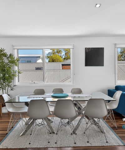 Bright dining area featuring large windows, modern furnishings, and an inviting atmosphere perfect for gatherings.