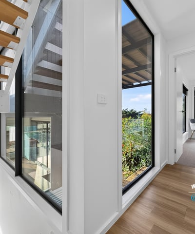 Bright, open hallways lead to inviting spaces with lush outdoor views and modern finishes.