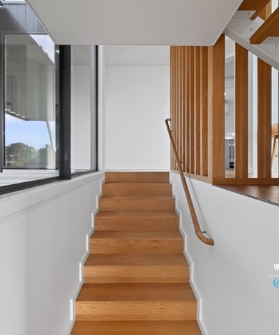 Modern staircase featuring sleek lines and natural light, seamlessly connecting spaces in a contemporary home.