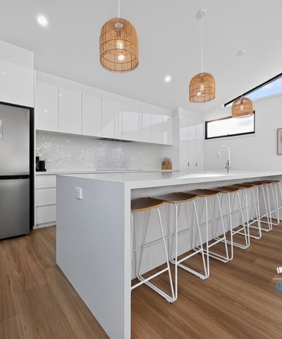 Modern kitchen featuring sleek cabinetry, a spacious island, natural light, and contemporary pendant lighting.