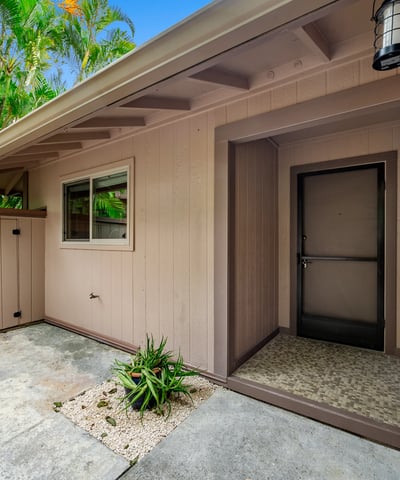 Welcoming entrance featuring unique architectural details, surrounded by lush landscaping and a private outdoor space.
