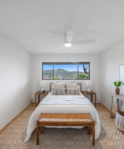 Bright bedroom featuring panoramic mountain views, modern furnishings, and natural light pouring in through large windows.