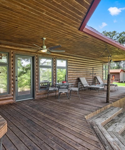 Spacious log home featuring a generous porch, ideal for outdoor living and relaxation surrounded by nature.