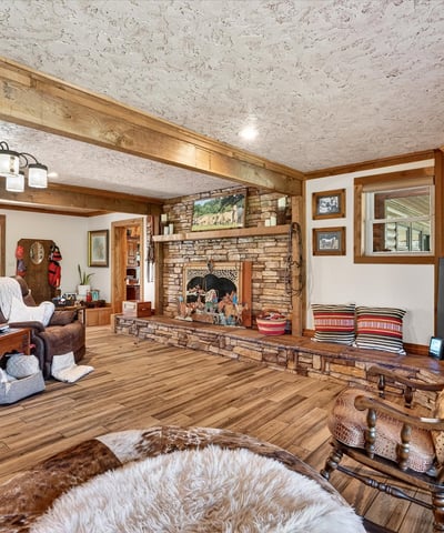 Discover a spacious living area featuring a unique stone fireplace and abundant natural light.
