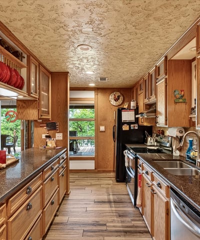 Spacious kitchen featuring ample cabinetry, granite countertops, and large windows that invite natural light.