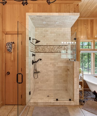 This luxurious bathroom features a spacious walk-in shower and a freestanding tub, surrounded by natural light.