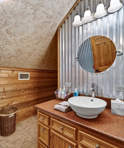 This unique bathroom features rustic wood accents and modern fixtures, creating a warm and inviting atmosphere.