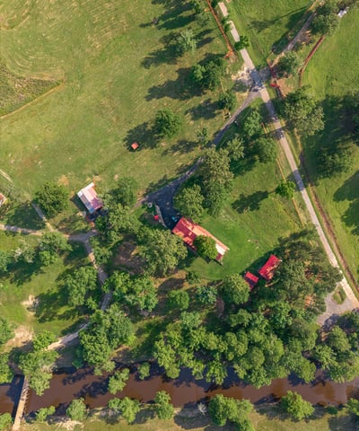 Discover a picturesque property featuring lush greenery, a winding river, and ample space for outdoor activities.