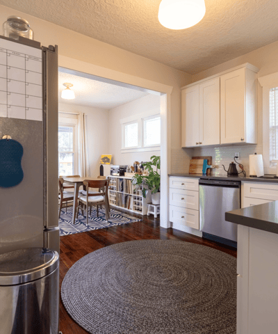 Bright kitchen featuring modern appliances, ample counter space, and an inviting dining area beyond.