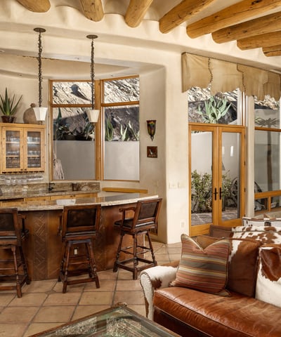 Host unforgettable gatherings at this custom wet bar, beautifully integrated into the open-concept great room. Natural stone accents, warm wood cabinetry, and views of the tranquil Zen garden create a perfect harmony of indoor luxury and outdoor serenity.