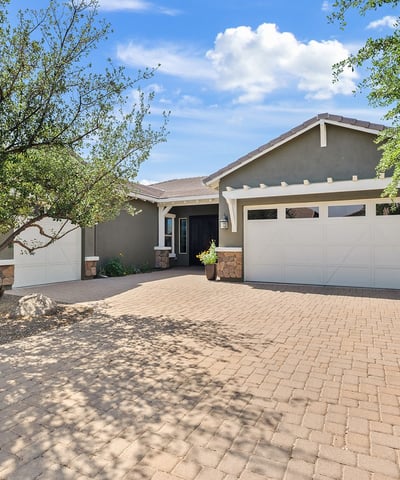 This beautifully designed Phoenix residence showcases stone accents, Craftsman-style architecture, desert landscaping, and a welcoming paver driveway that highlights pride of ownership and timeless design.