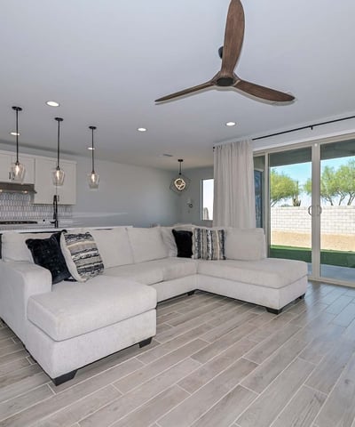 Experience seamless indoor-outdoor flow with this open layout, showcasing upgraded flooring, a statement fan, and sliders to the backyard.