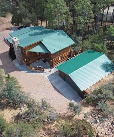 Aerial view capturing the home s layout and wooded surroundings. This perspective highlights privacy, generous outdoor space, and the peaceful setting found in this Prescott retreat.