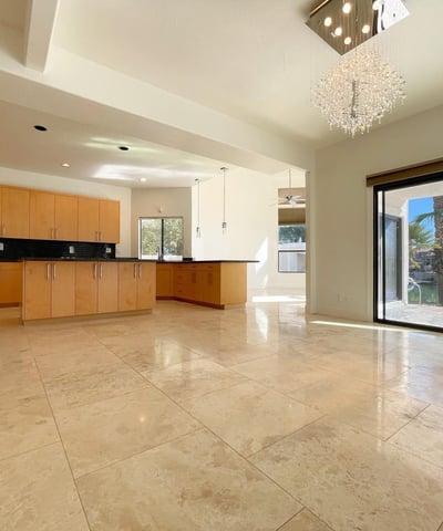 Bright kitchen-dining area with elegant tile floors, crystal lighting, and sliding doors opening to waterfront views ideal for entertaining in style.