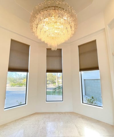 Graceful dining area framed by tall windows and a sparkling chandelier, creating a luxurious setting for intimate gatherings.