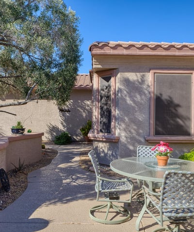 Gather under the Arizona sun in this inviting front patio with privacy walls and mature trees. A perfect outdoor retreat for morning coffee or evening relaxation.