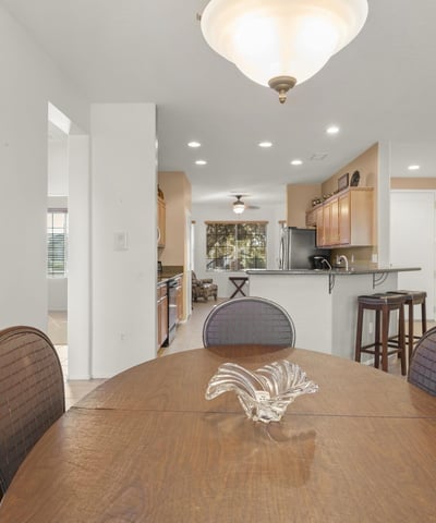 Sun-filled dining area with open access to the kitchen and living room, creating a perfect flow for entertaining and casual dining in this stunning Surprise home.