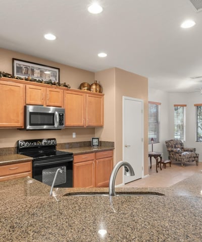 The kitchen shines with durable granite countertops, stainless fixtures, and warm tones offering both elegance and easy maintenance for Arizona living.
