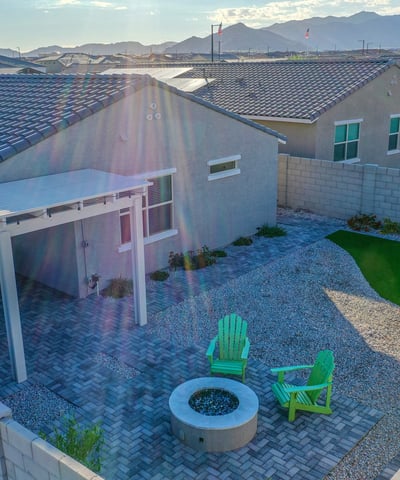 Aerial photography showcases the home s impressive backyard layout, complete with turf, paver patios, fire pit, and landscaped borders an attractive outdoor upgrade in Litchfield Park.