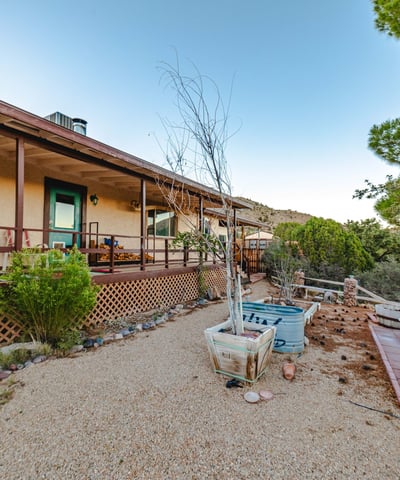 Gravel paths, raised beds, and shaded seating areas enhance this peaceful outdoor zone. The wraparound deck creates an inviting extension of the home s living space.