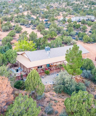 An inviting aerial showcases the property s serene placement among natural vegetation, offering privacy, mountain views, and ample usable land for future vision.